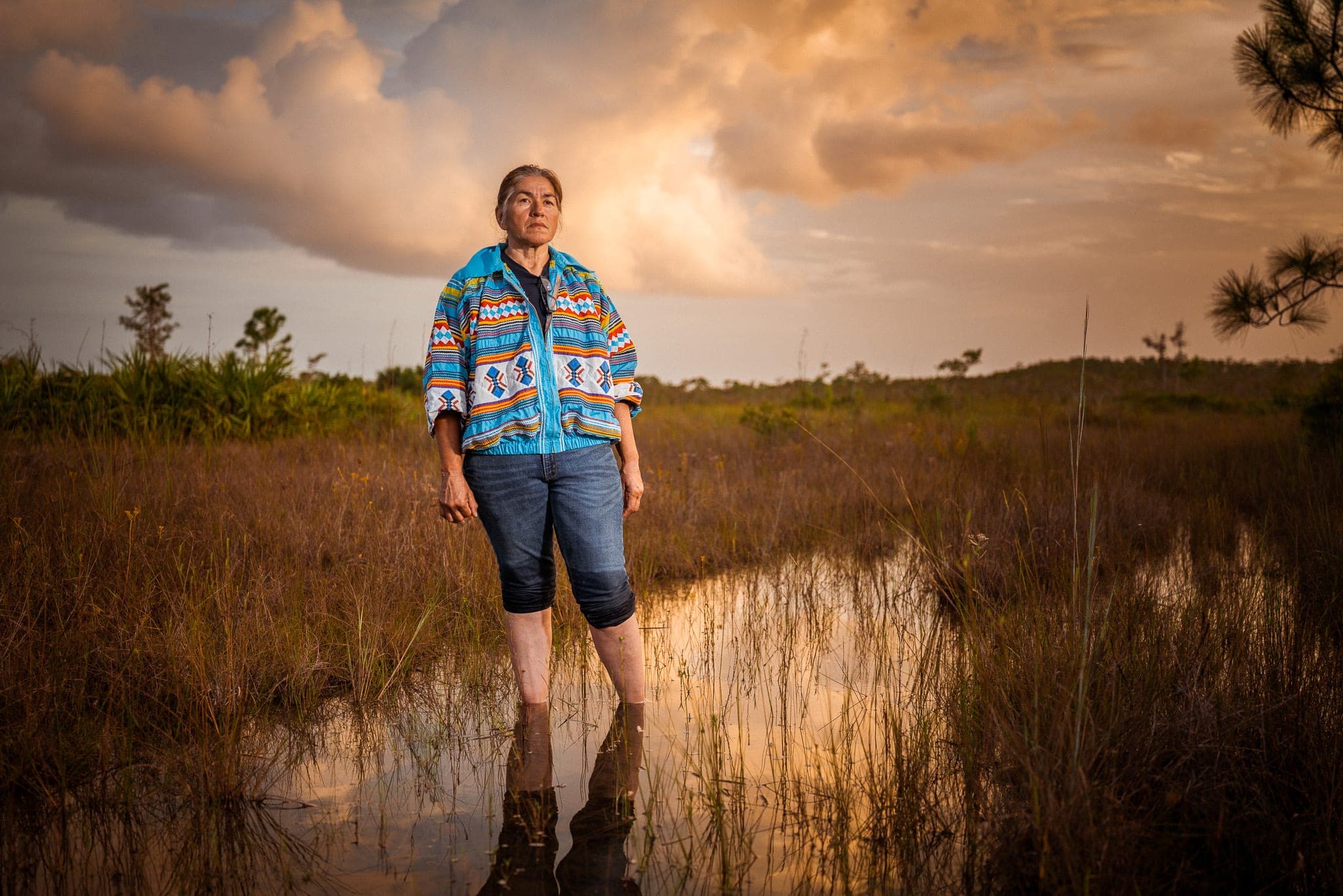 A field worker in a marsh landscape — the field production an NGO turns into advocacy and fundraising assets