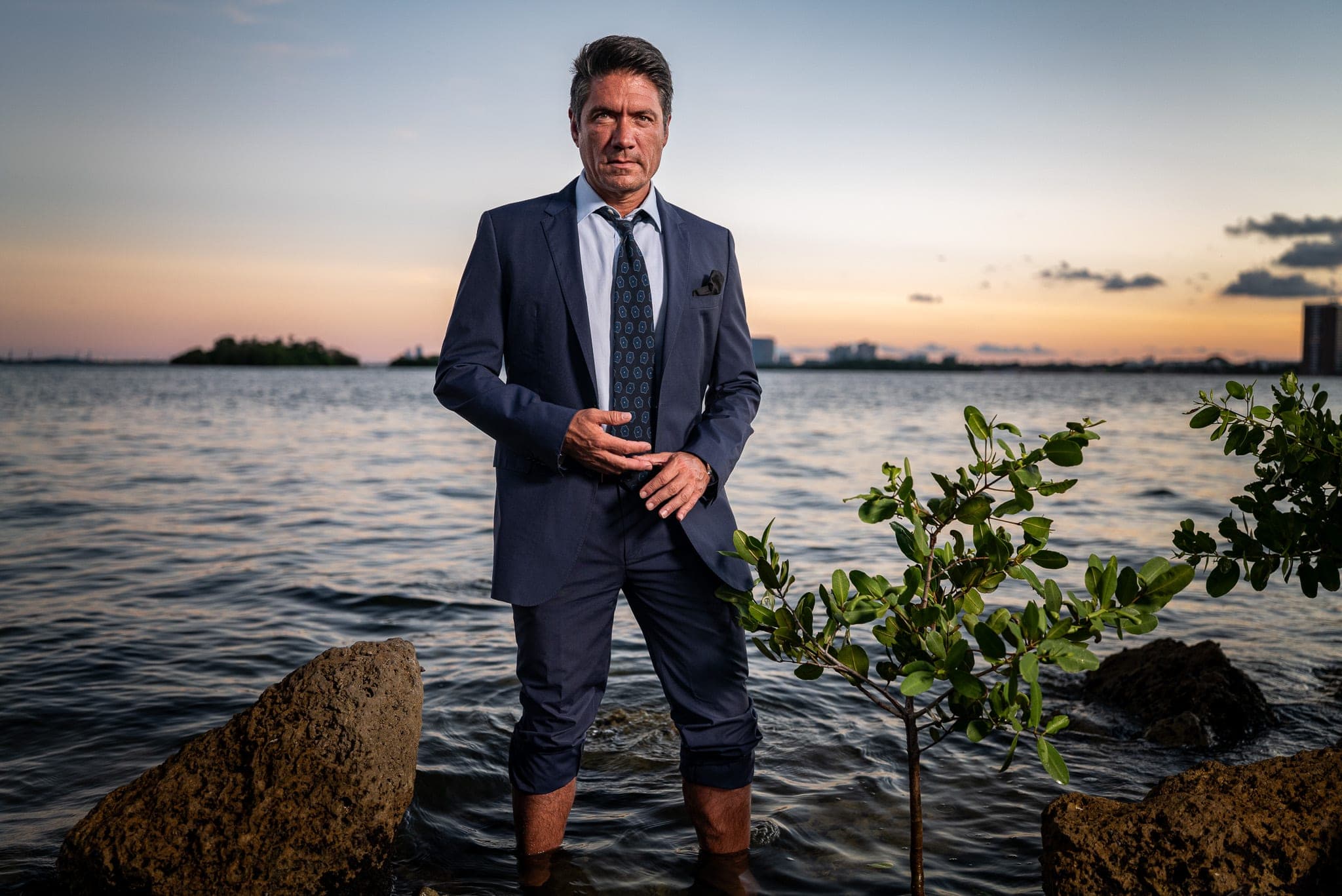 A subject photographed at the water's edge, the city skyline behind — the mission-world context the benchmark data is drawn from
