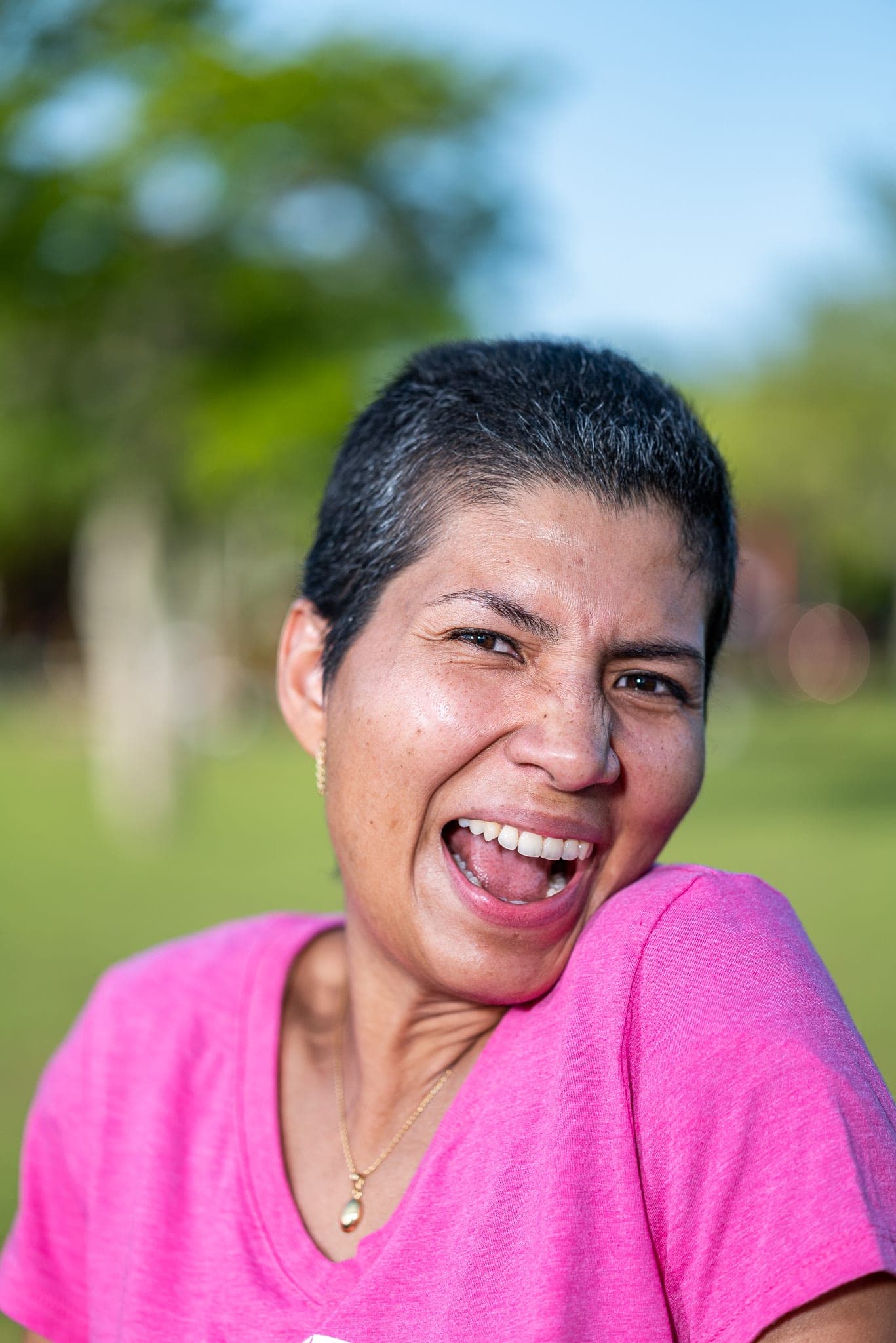 A woman laughing mid-conversation — the human at the center of every Cue suggestion