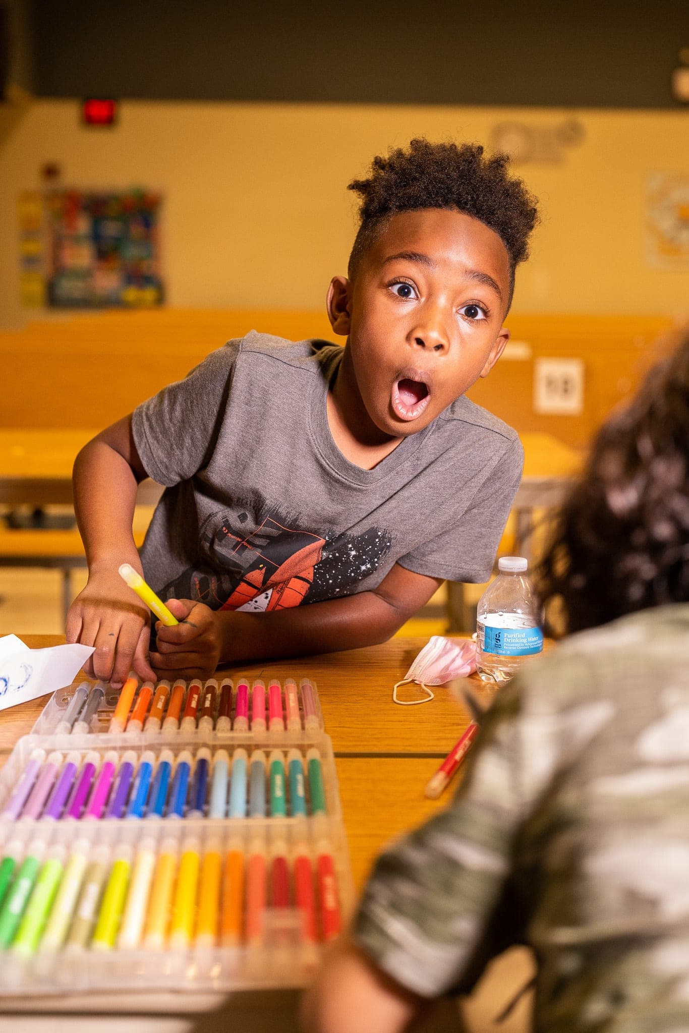 A boy reacts with delight at a youth-program table — the kind of moment StoryMine surfaces from hours of footage